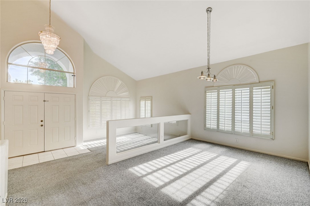 3901 Triora Street Las Vegas, NV 89129 - Photo 4 of 42 Entrance foyer with a chandelier, high vaulted ceiling, and carpet flooring