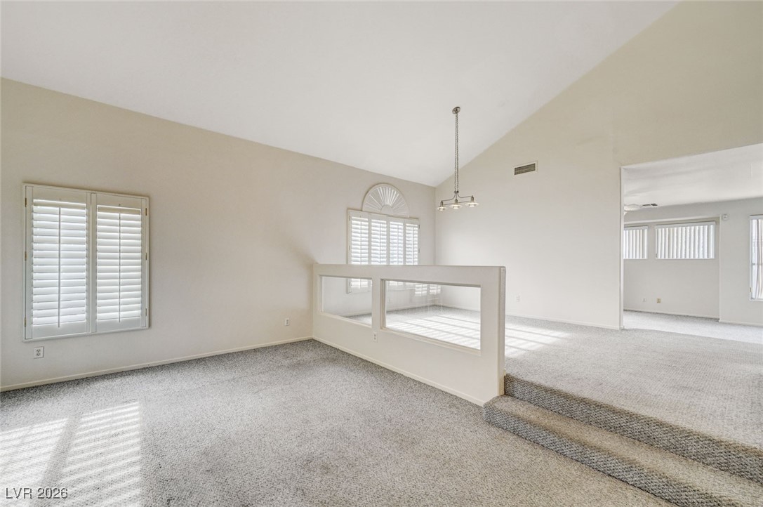 3901 Triora Street Las Vegas, NV 89129 - Photo 6 of 42 Carpeted spare room featuring high vaulted ceiling and healthy amount of natural light
