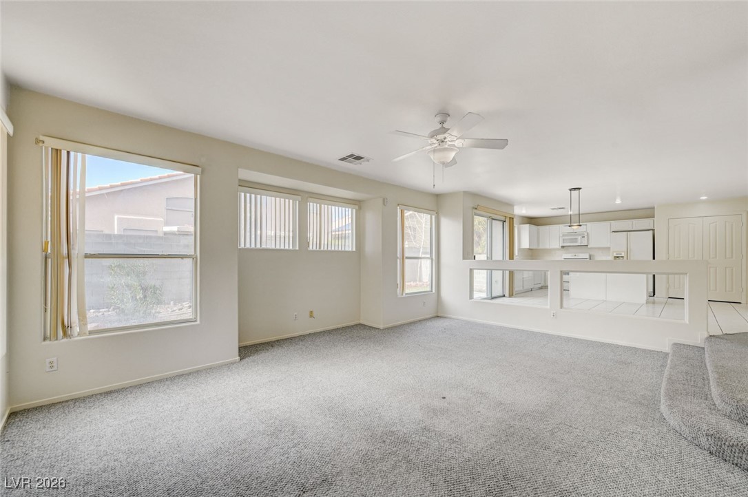 3901 Triora Street Las Vegas, NV 89129 - Photo 10 of 42 Unfurnished living room featuring carpet floors, healthy amount of natural light, and a ceiling fan