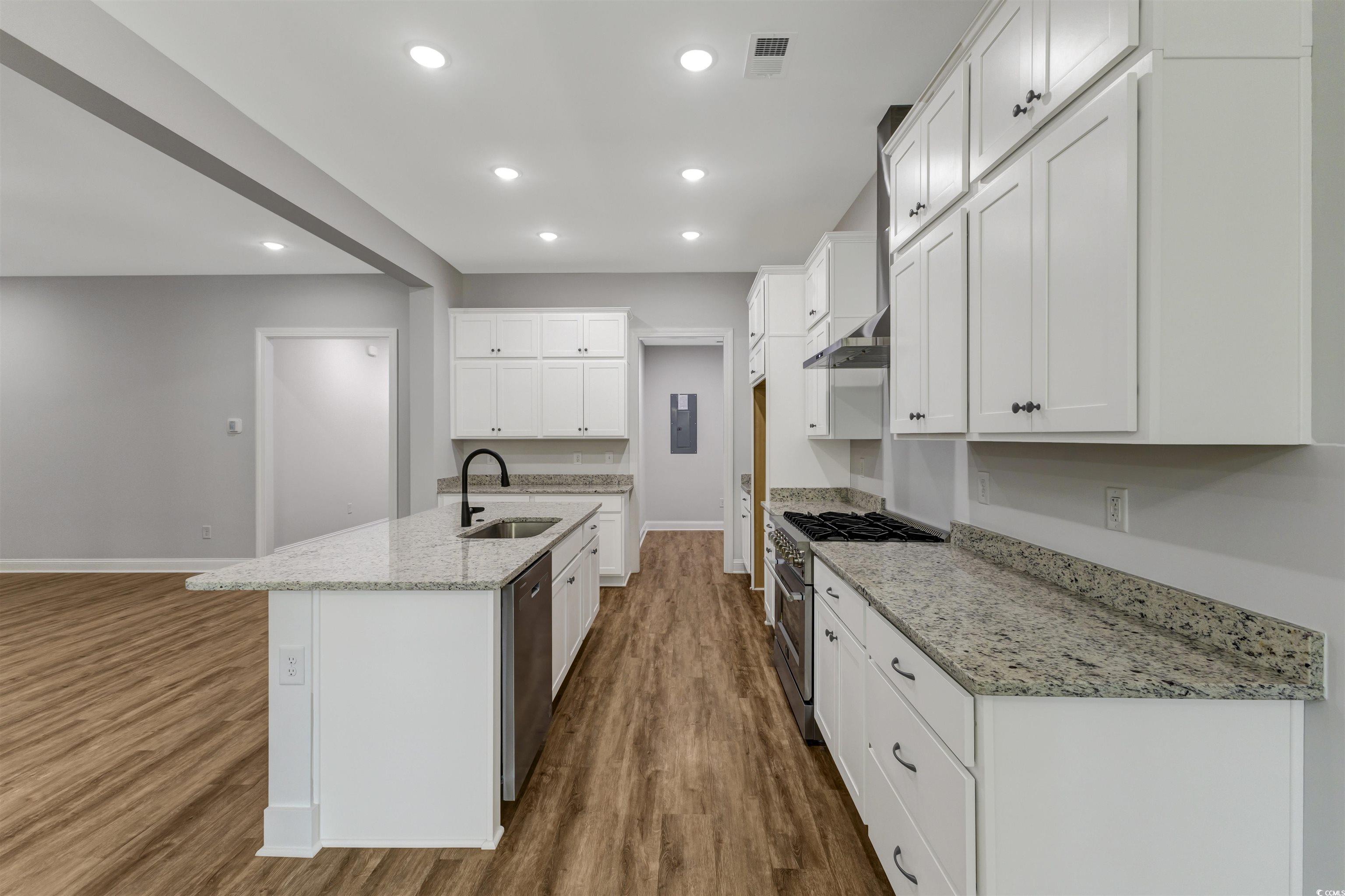 4121 Whatuthink Road Myrtle Beach, SC 29588 - Photo 11 of 28 Kitchen with a sink, gas stove, dishwasher, baseboards, LVP flooring, and white cabinets