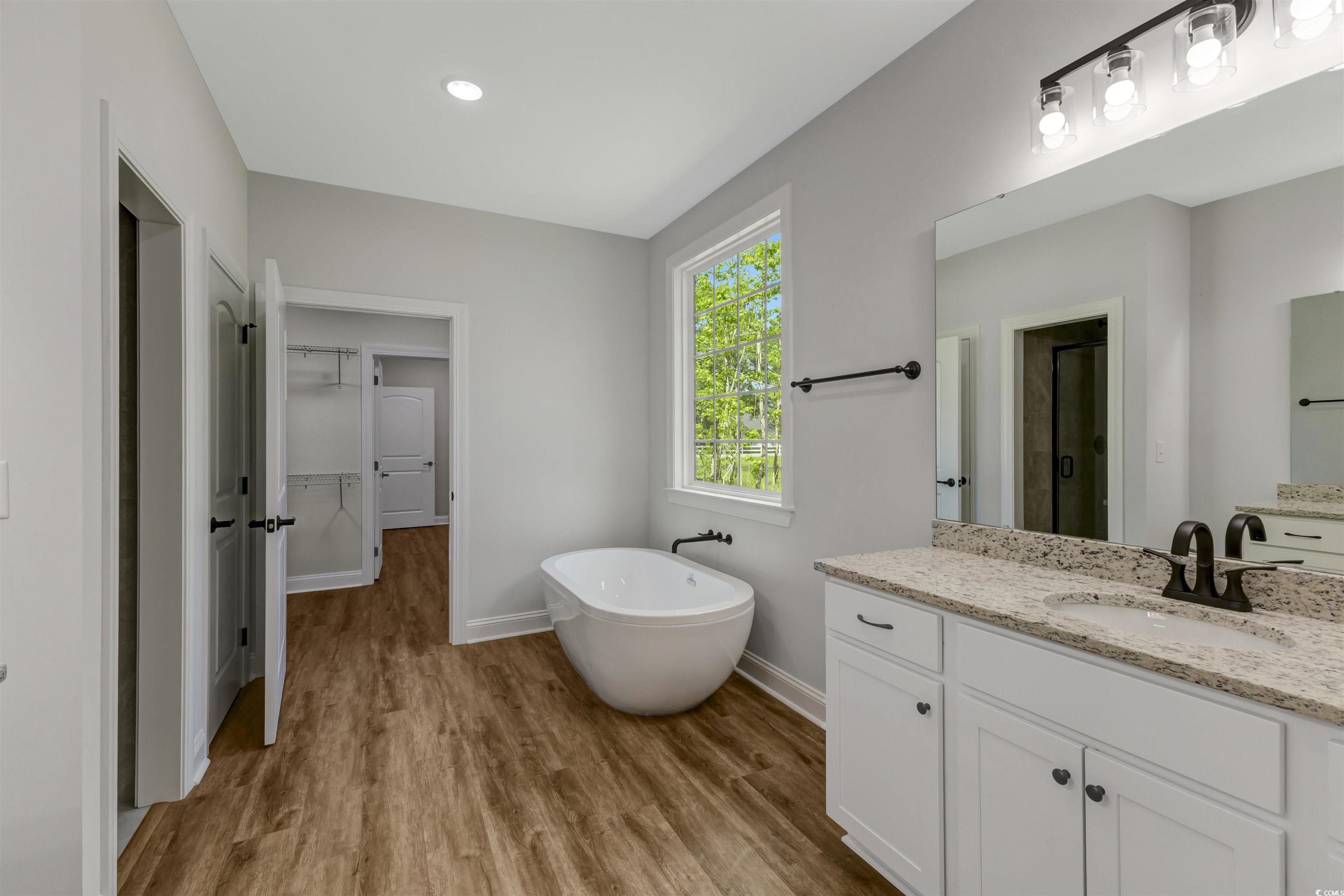 4121 Whatuthink Road Myrtle Beach, SC 29588 - Photo 17 of 28 Master bathroom with double sinks, a stall shower, a freestanding tub, and vanity
