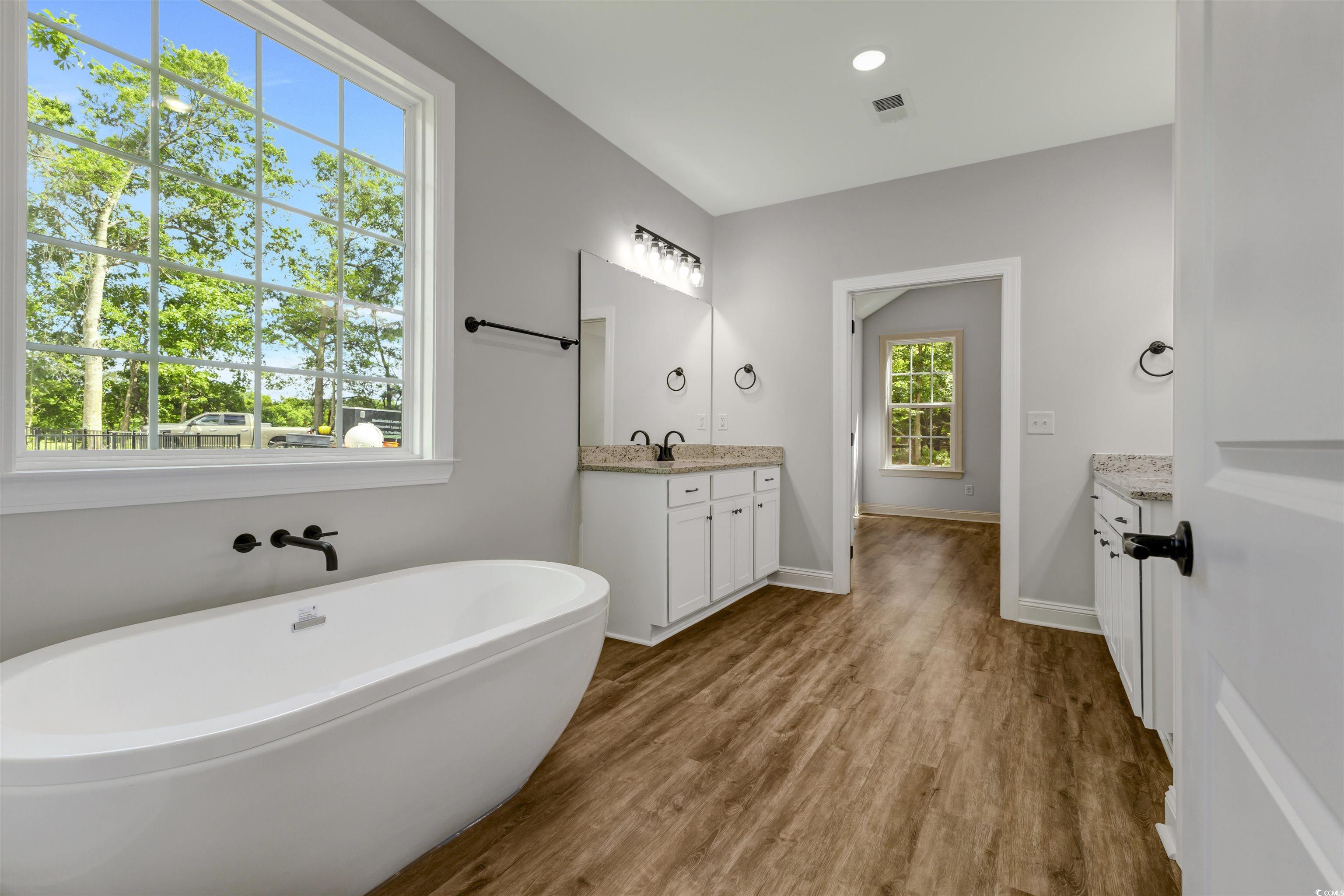 4121 Whatuthink Road Myrtle Beach, SC 29588 - Photo 18 of 28 Master bathroom with vanity, a freestanding tub, and baseboards