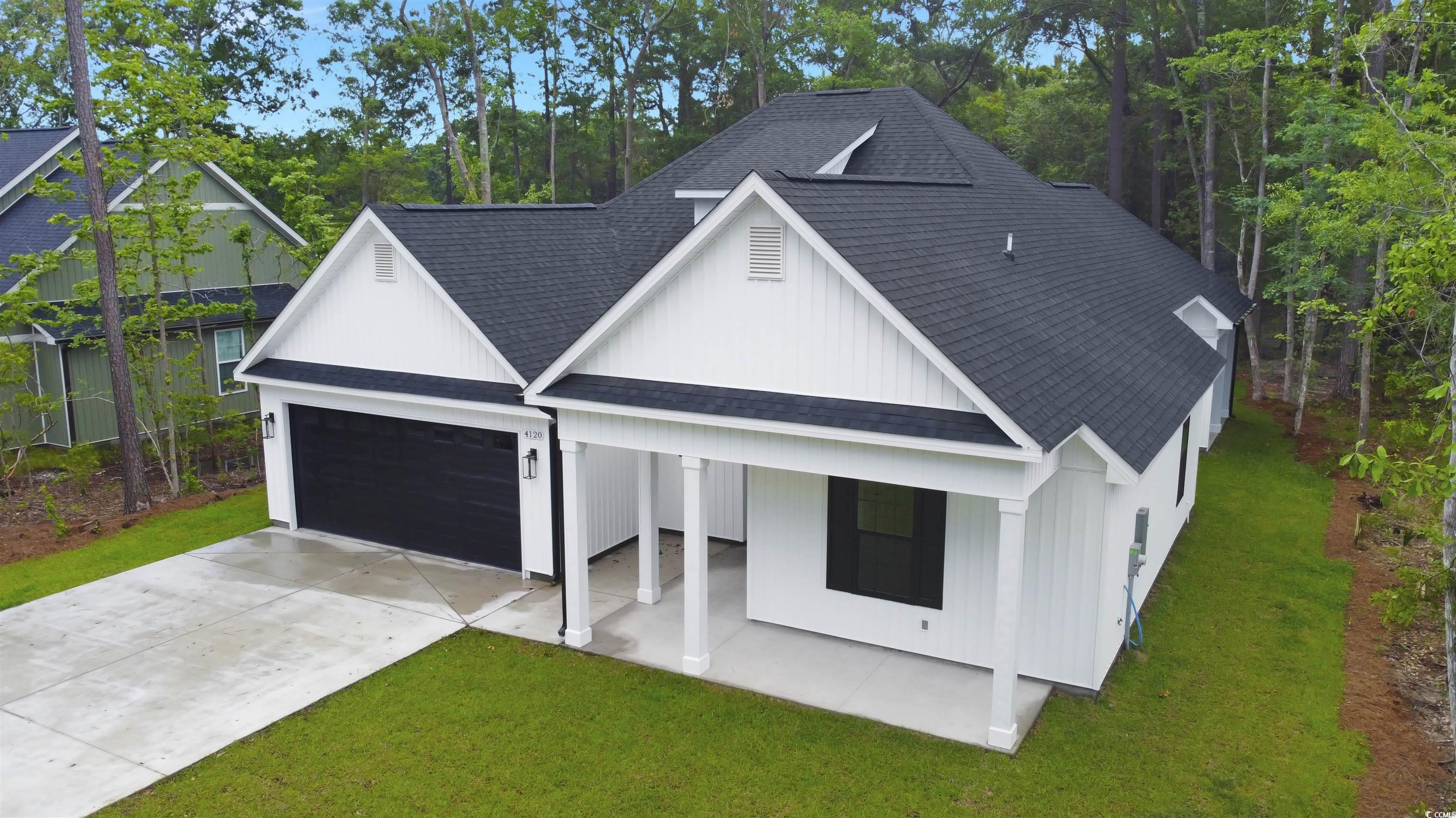 4121 Whatuthink Road Myrtle Beach, SC 29588 - Photo 2 of 28 View of front of property featuring a shingled roof, a front yard, concrete driveway, covered porch, and a garage