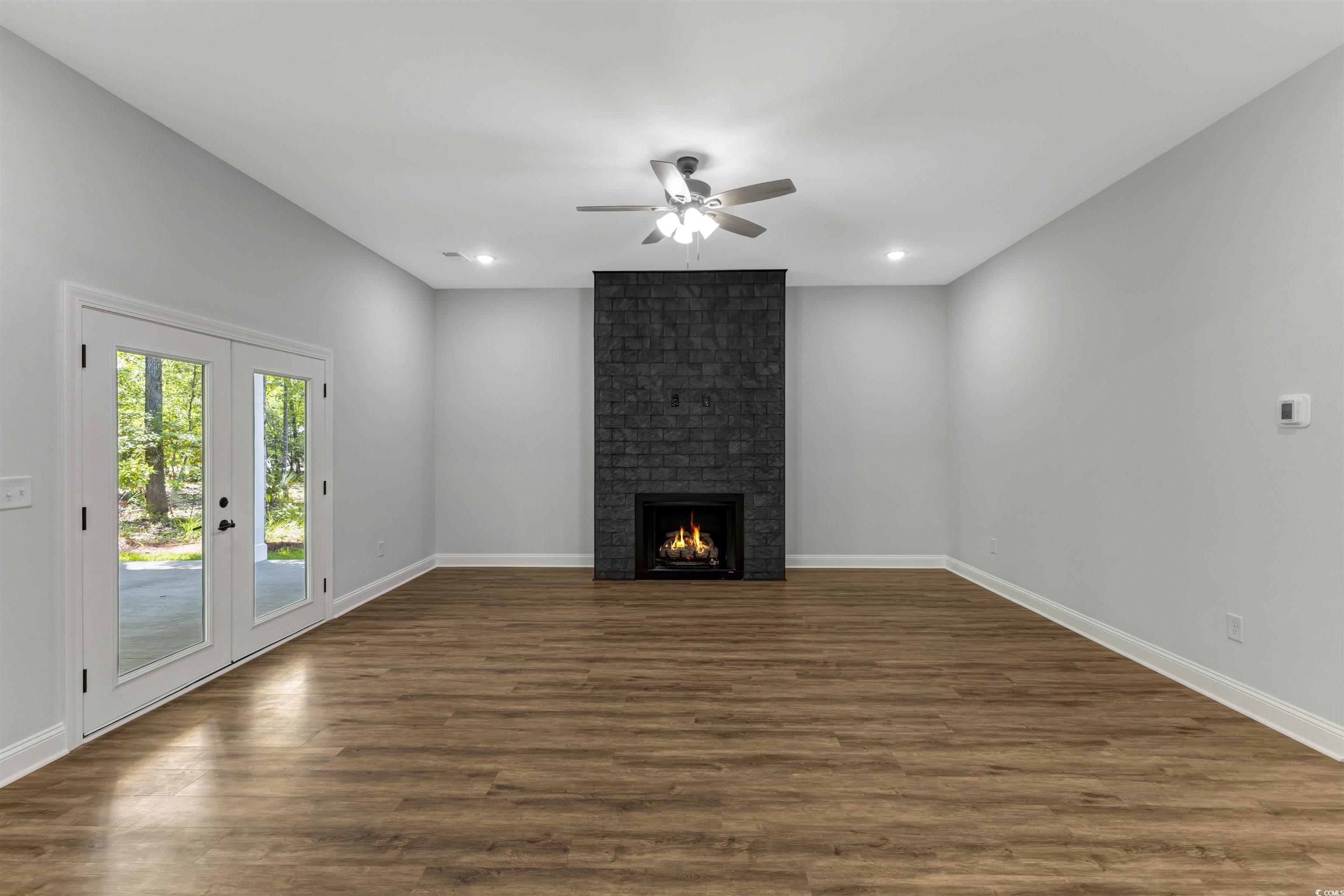 4121 Whatuthink Road Myrtle Beach, SC 29588 - Photo 7 of 28 Unfurnished living room featuring ceiling fan, LVP flooring, a fireplace, and recessed lighting