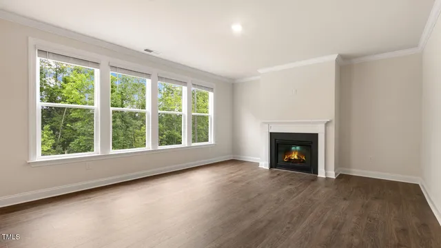 wooden floor fireplace and windows in an empty room