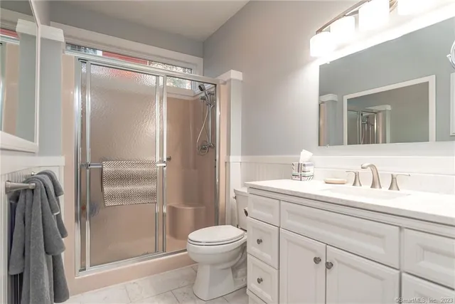 a bathroom with a granite countertop sink toilet and shower