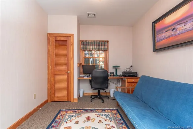 a view of a workspace with furniture and a window