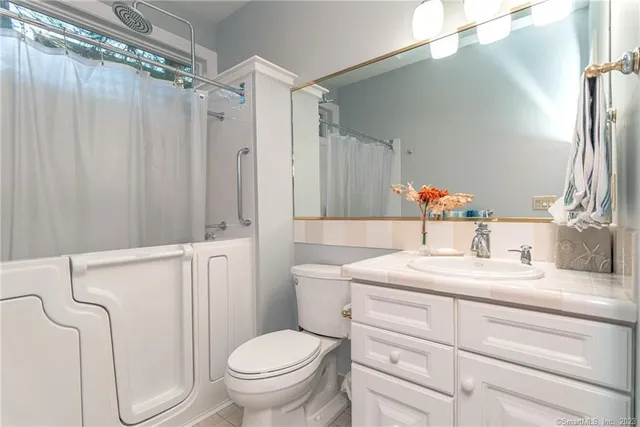 a bathroom with a granite countertop sink toilet and shower