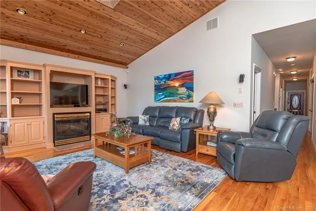 a living room with furniture flat screen tv and wooden floor