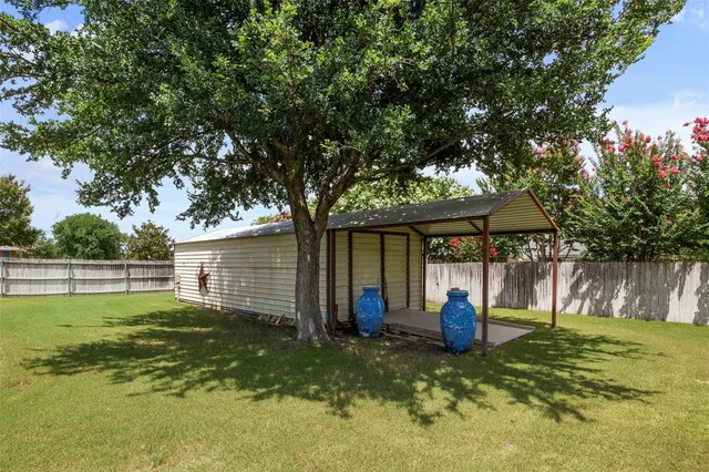 a backyard of a house with barbeque oven table and chairs