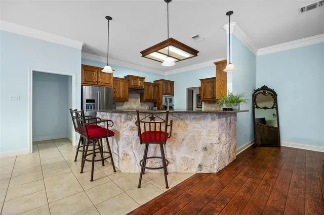 a view of a room with gym equipment and wooden floor