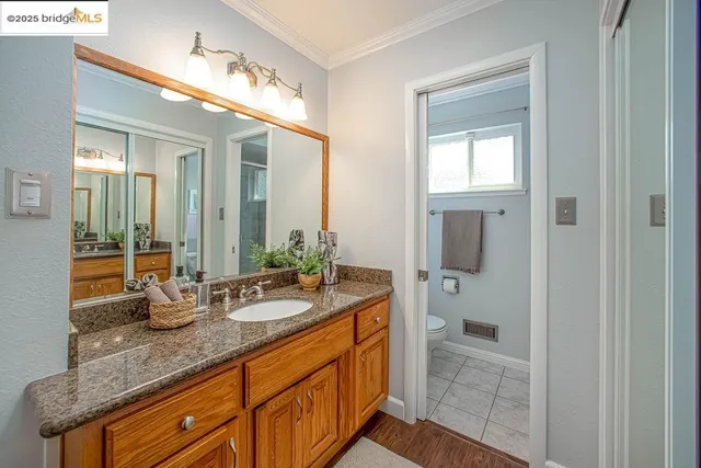 a white toilet sitting next to a window in a bathroom