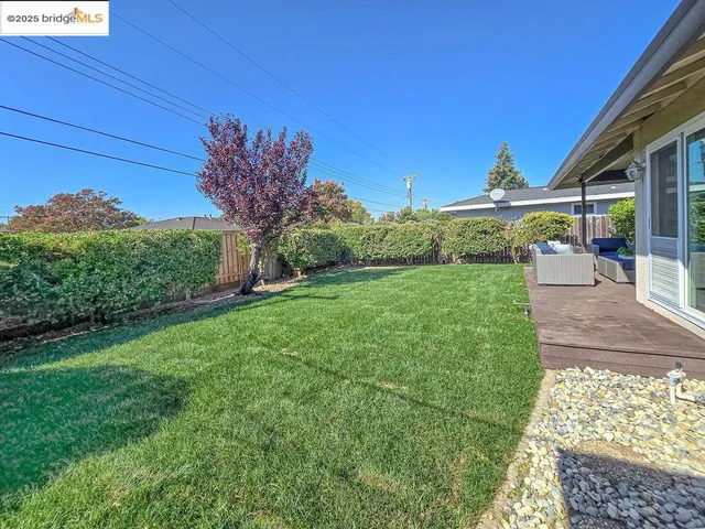 a view of a house with backyard and wooden fence