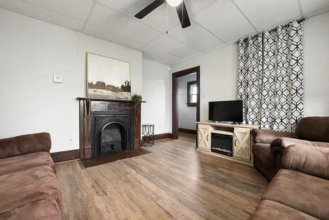 a living room with furniture a flat screen tv and a fireplace