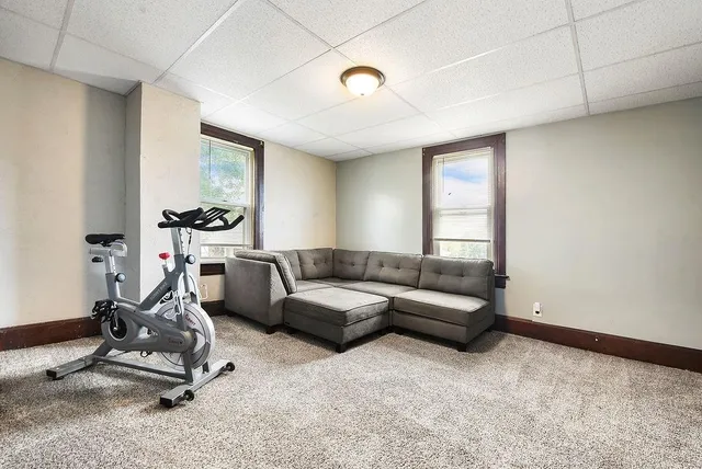 a living room with furniture a window and gym equipment