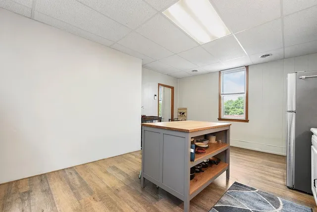 a room with kitchen island a wooden floor and window