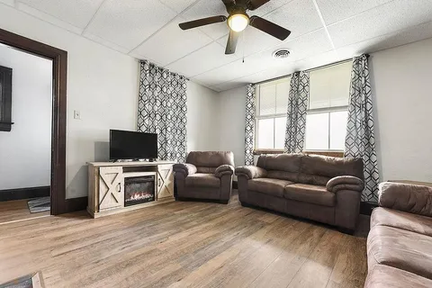 a living room with furniture a flat screen tv and a window