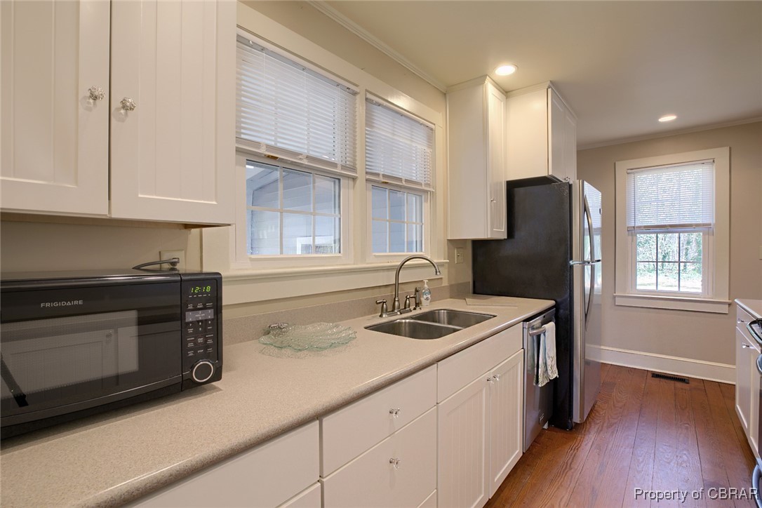 10371 Buckley Hall Road Mathews, VA 23109 - Photo 6 of 28 Kitchen featuring white cabinetry, a sink, black microwave, and stainless steel dishwasher