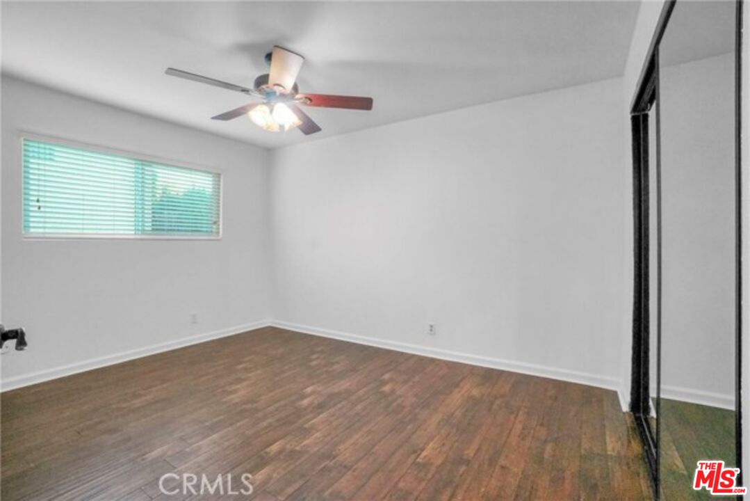5003 Tilden Avenue, Unit 109 Sherman Oaks, CA 91423 - Photo 12 of 29 an empty room with wooden floor fan and windows