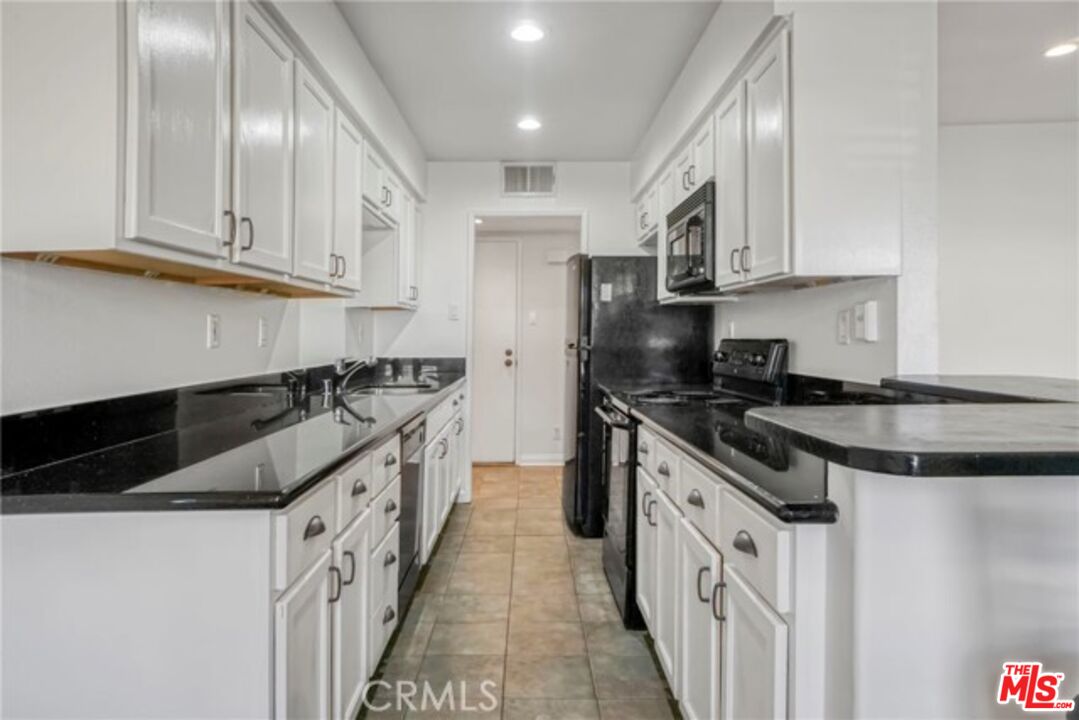 5003 Tilden Avenue, Unit 109 Sherman Oaks, CA 91423 - Photo 2 of 29 a kitchen with granite countertop a sink stove and cabinets