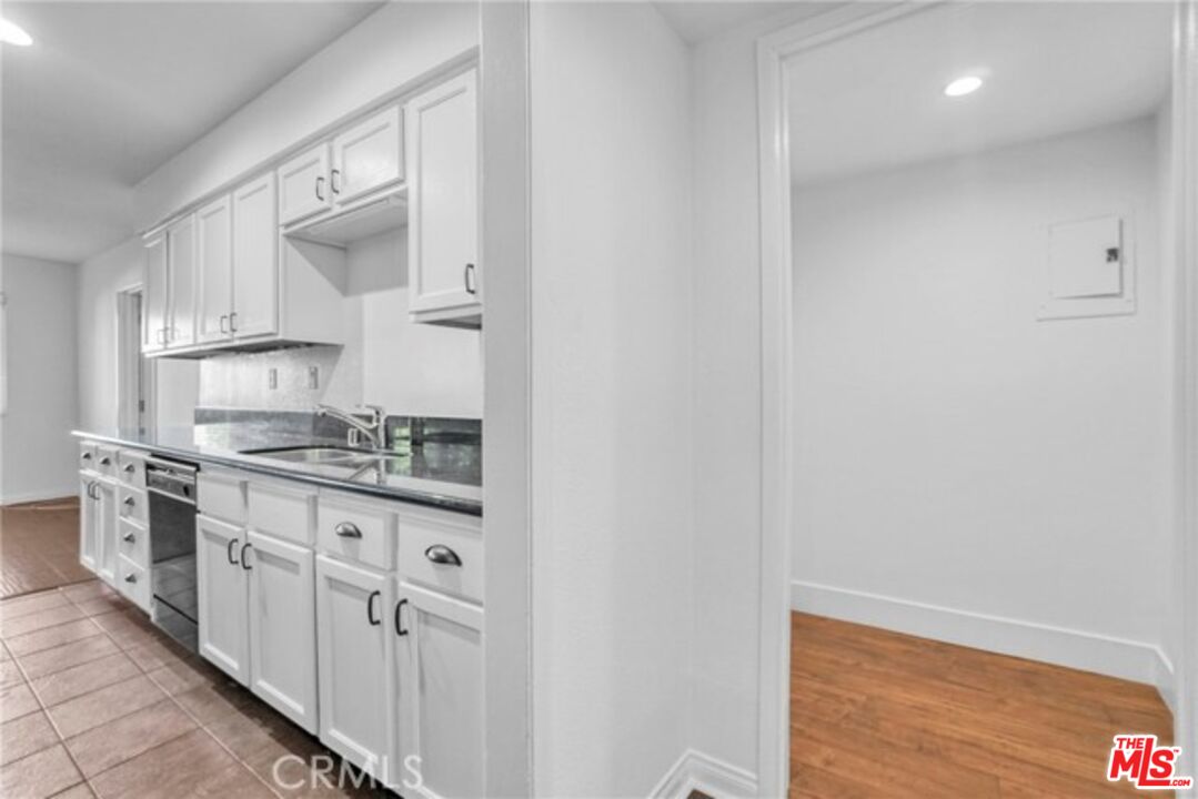 5003 Tilden Avenue, Unit 109 Sherman Oaks, CA 91423 - Photo 3 of 29 a kitchen with stainless steel appliances granite countertop white cabinets and window