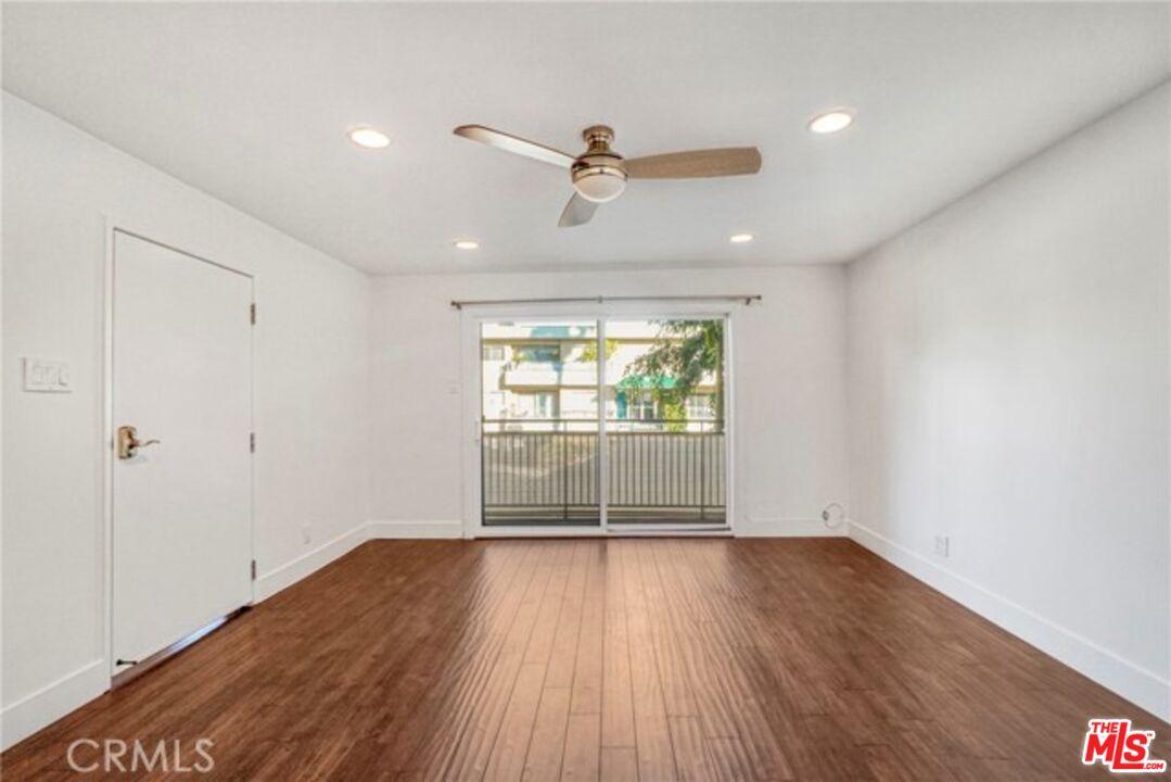 5003 Tilden Avenue, Unit 109 Sherman Oaks, CA 91423 - Photo 10 of 29 an empty room with wooden floor and windows
