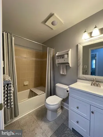 a bathroom with a bathtub shower sink vanity and toilet