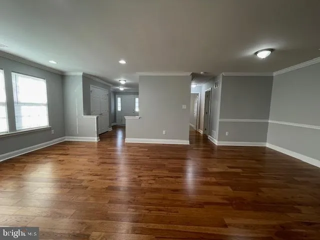 a view of empty room with wooden floor and windows