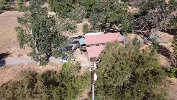 an aerial view of house with yard and mountain view in back