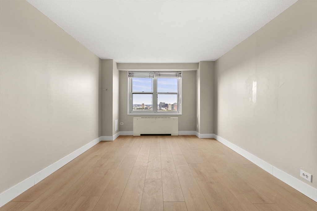 151 Tremont Street, Unit 23P Boston, MA 02111 - Photo 17 of 35 an empty room with windows and cabinet