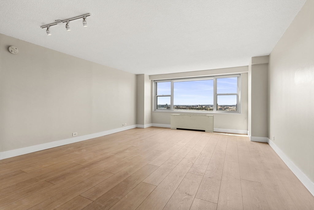 151 Tremont Street, Unit 23P Boston, MA 02111 - Photo 2 of 35 a view of an empty room with a kitchen and a window
