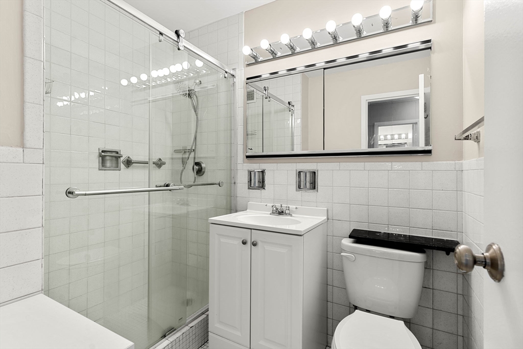 151 Tremont Street, Unit 23P Boston, MA 02111 - Photo 21 of 35 a bathroom with a toilet sink and mirror