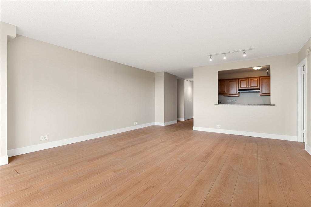 151 Tremont Street, Unit 23P Boston, MA 02111 - Photo 5 of 35 a view of an empty room with wooden floor and a window