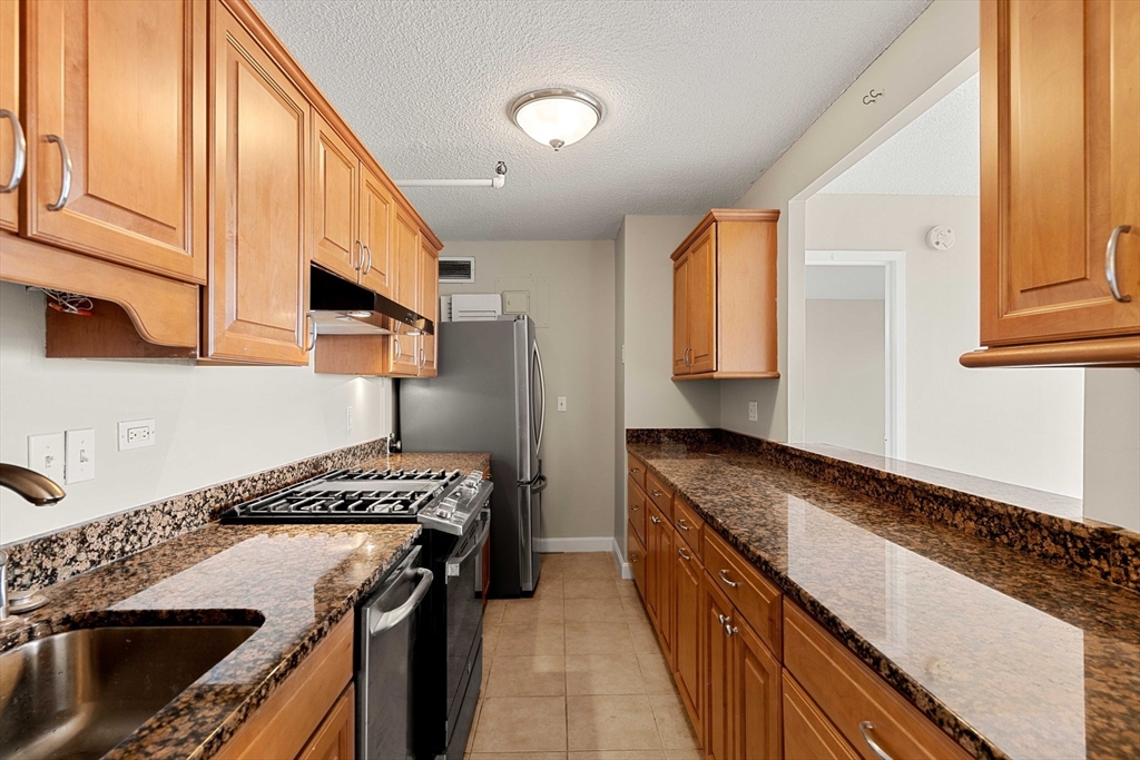 151 Tremont Street, Unit 23P Boston, MA 02111 - Photo 8 of 35 a kitchen with a stove and a refrigerator