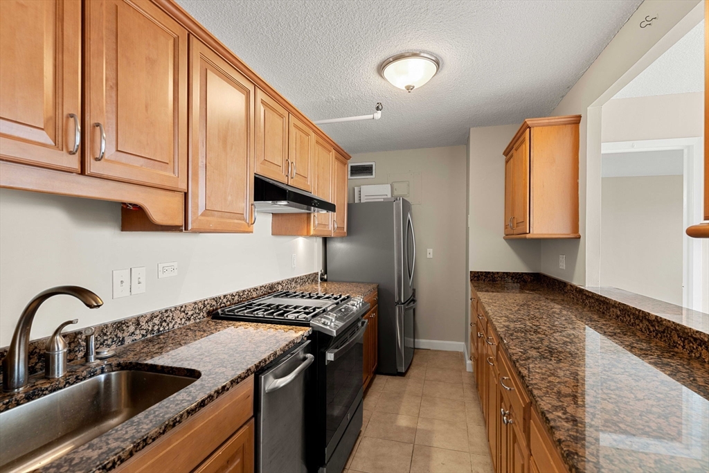 151 Tremont Street, Unit 23P Boston, MA 02111 - Photo 10 of 35 a kitchen with stainless steel appliances granite countertop a sink stove and cabinets
