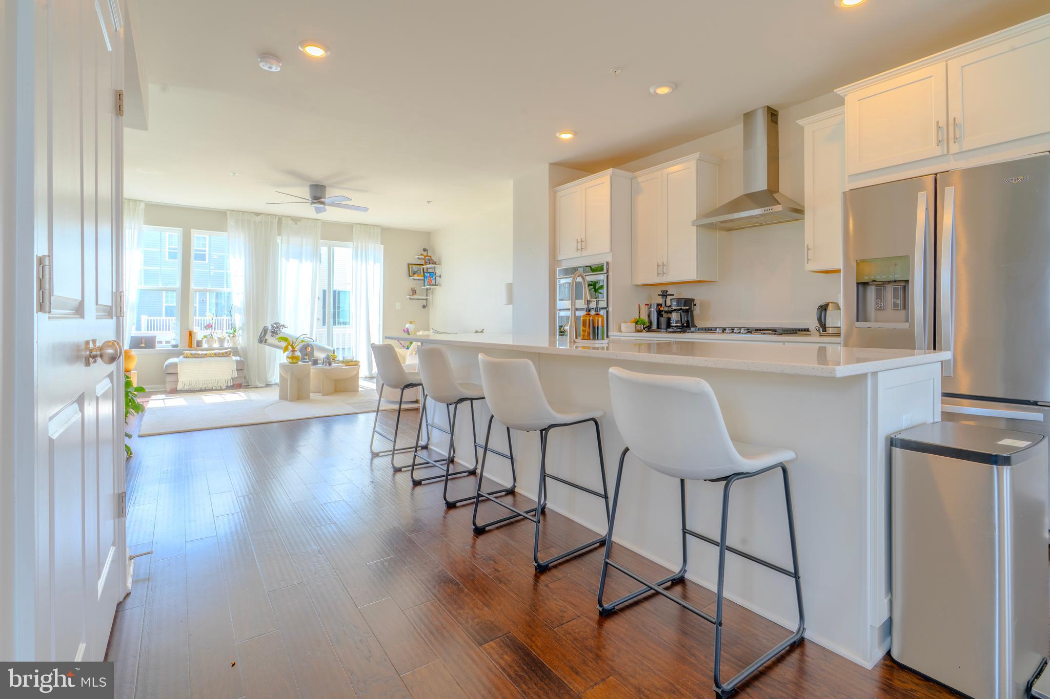 8515 Bald Eagle Lane Frederick, MD 21704 - Photo 15 of 34 a kitchen with stainless steel appliances a dining table chairs refrigerator and sink