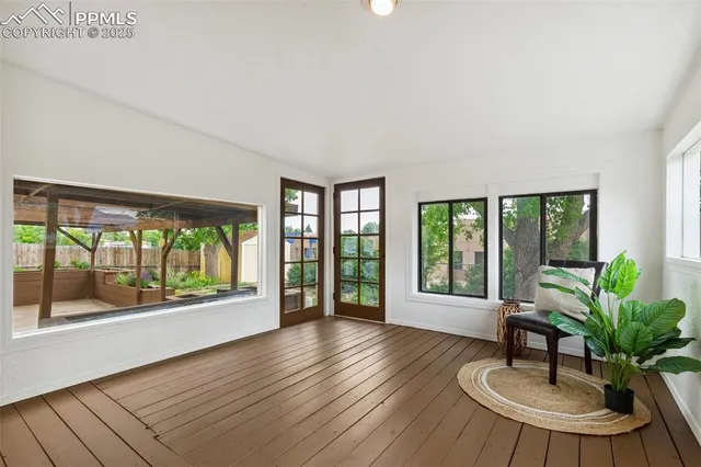 a living room with furniture and a large window with wooden floor