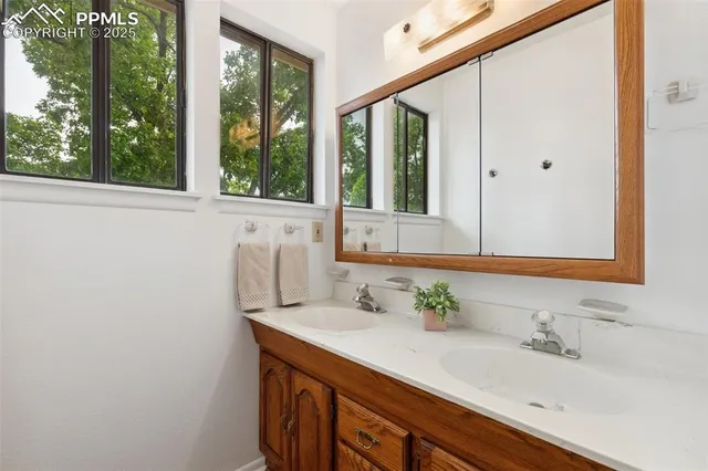 a bathroom with a granite countertop sink and a mirror