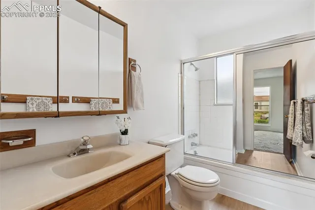 a bathroom with a toilet a sink and a large mirror