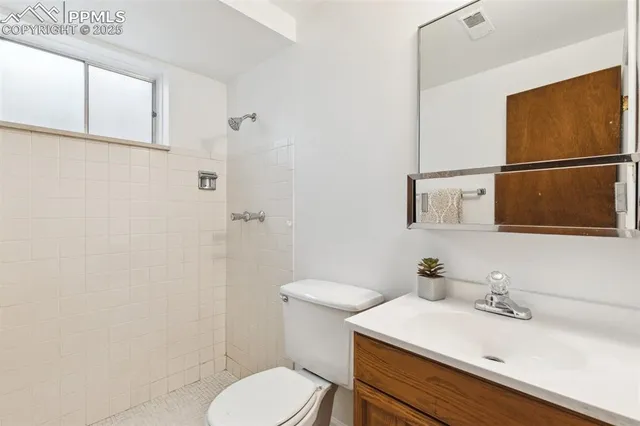a view of a livingroom with wooden floor and a ceiling fan
