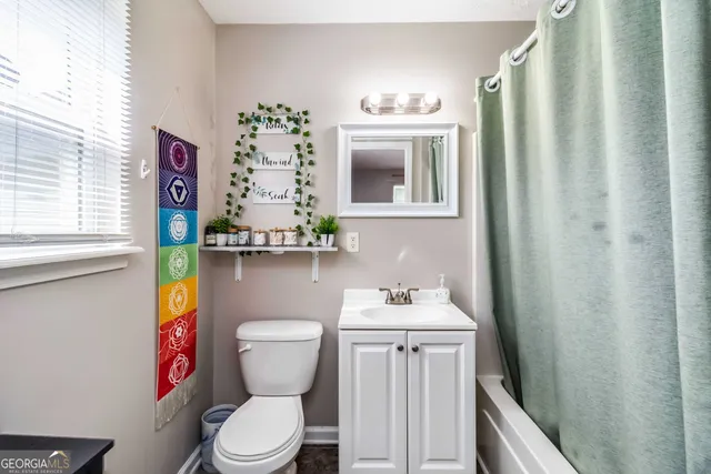 a bathroom with a toilet a sink and a mirror