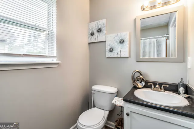 a bathroom with a toilet a sink and mirror