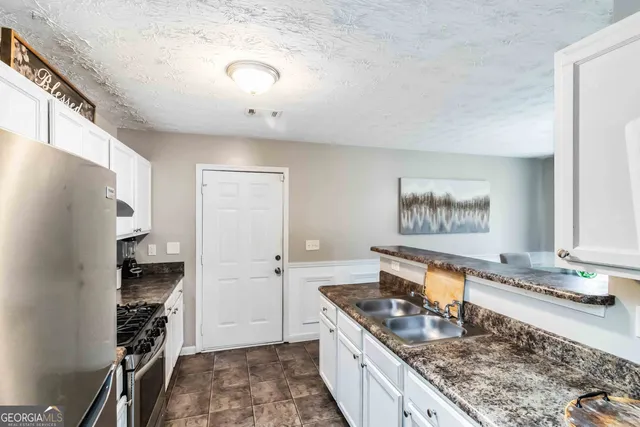 a kitchen with stainless steel appliances granite countertop a stove and a refrigerator