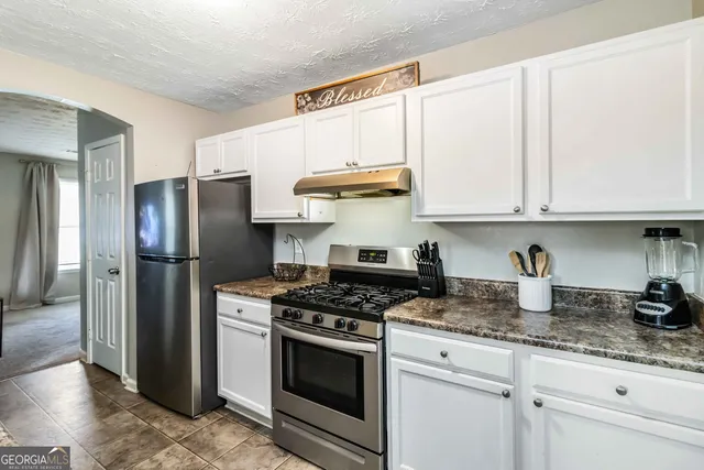 a kitchen with stainless steel appliances granite countertop a stove a refrigerator and a granite counter tops