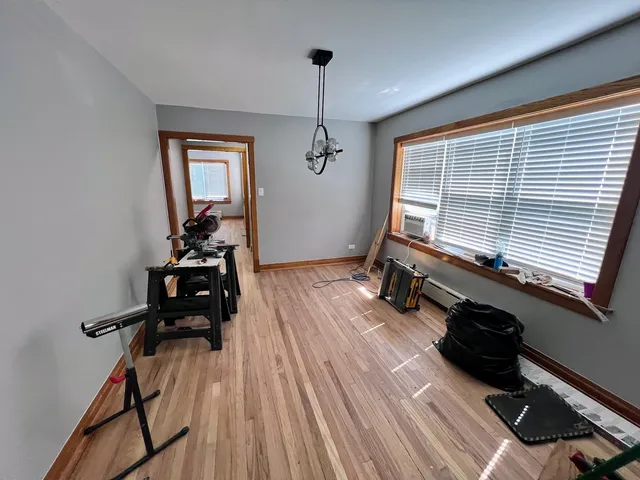 a room with gym equipment and wooden floor
