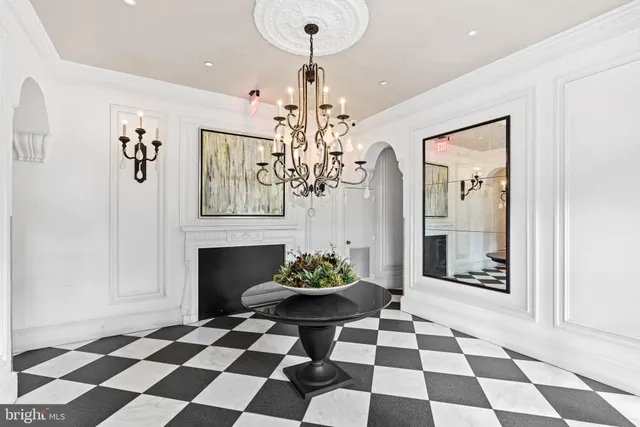 a room with a black and white checkered floor with a chandelier