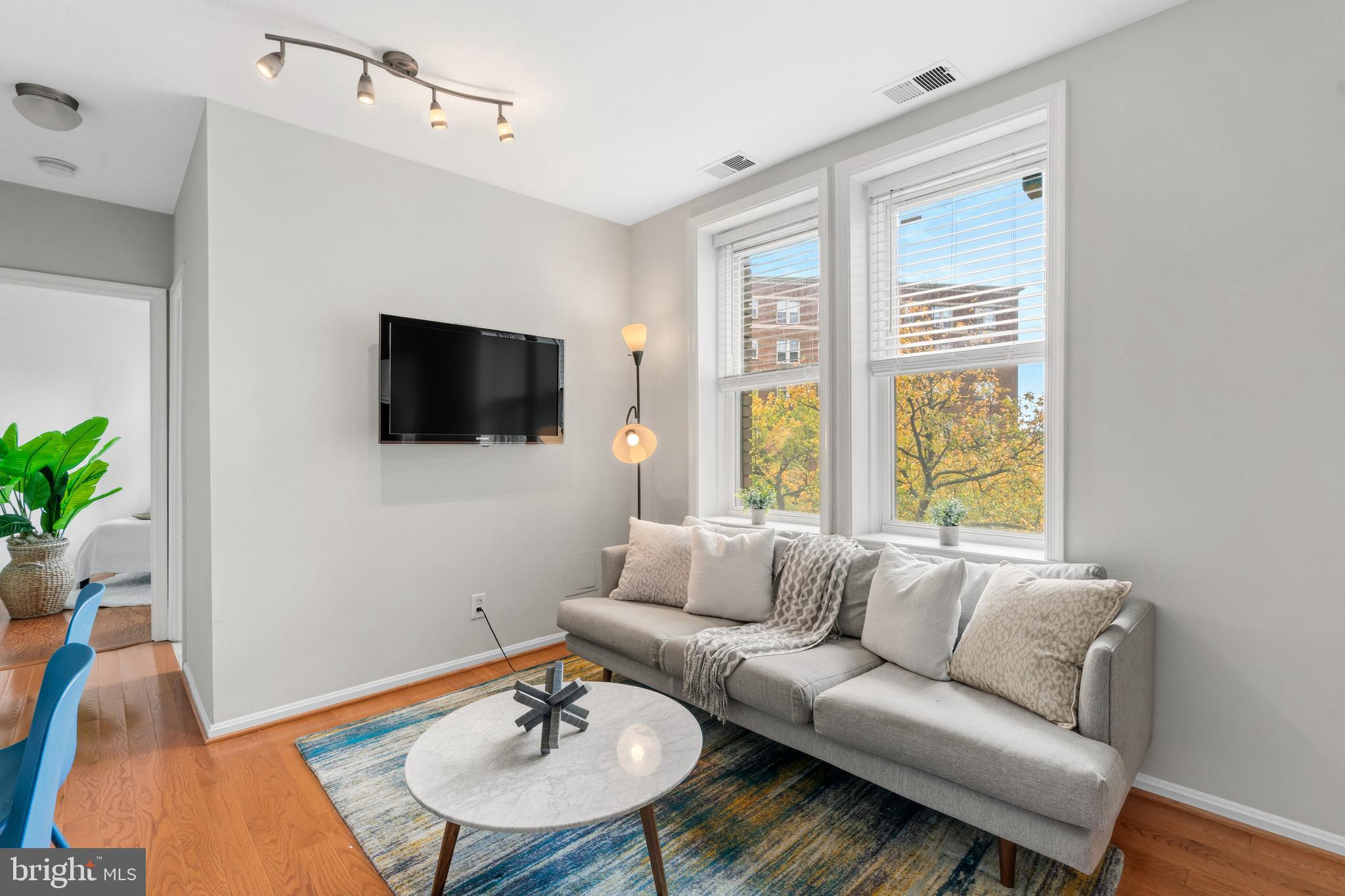 2001 16th Street Northwest, Unit 404 Washington, DC 20009 - Photo 7 of 17 a living room with furniture a flat screen tv and a window