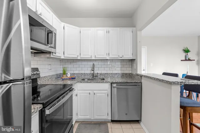 a kitchen with stainless steel appliances granite countertop a sink stove microwave and cabinets