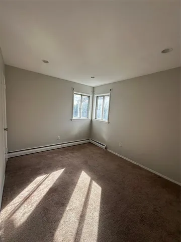 an empty room with windows and chandelier fan