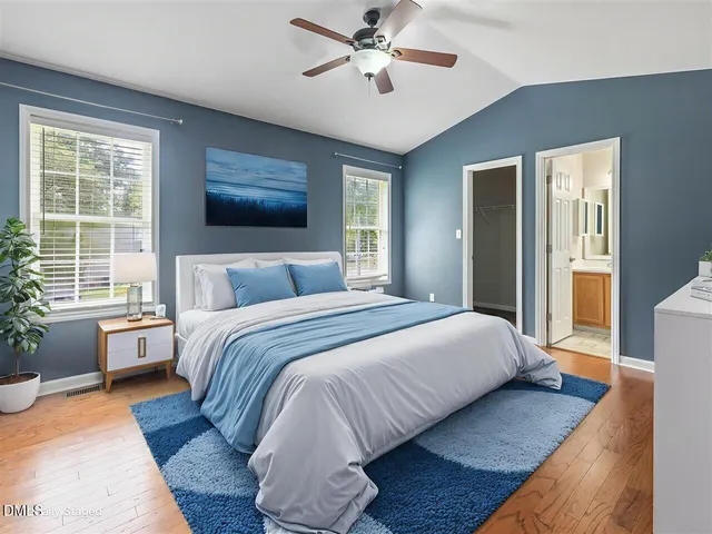 a bedroom with a large bed and a chandelier fan